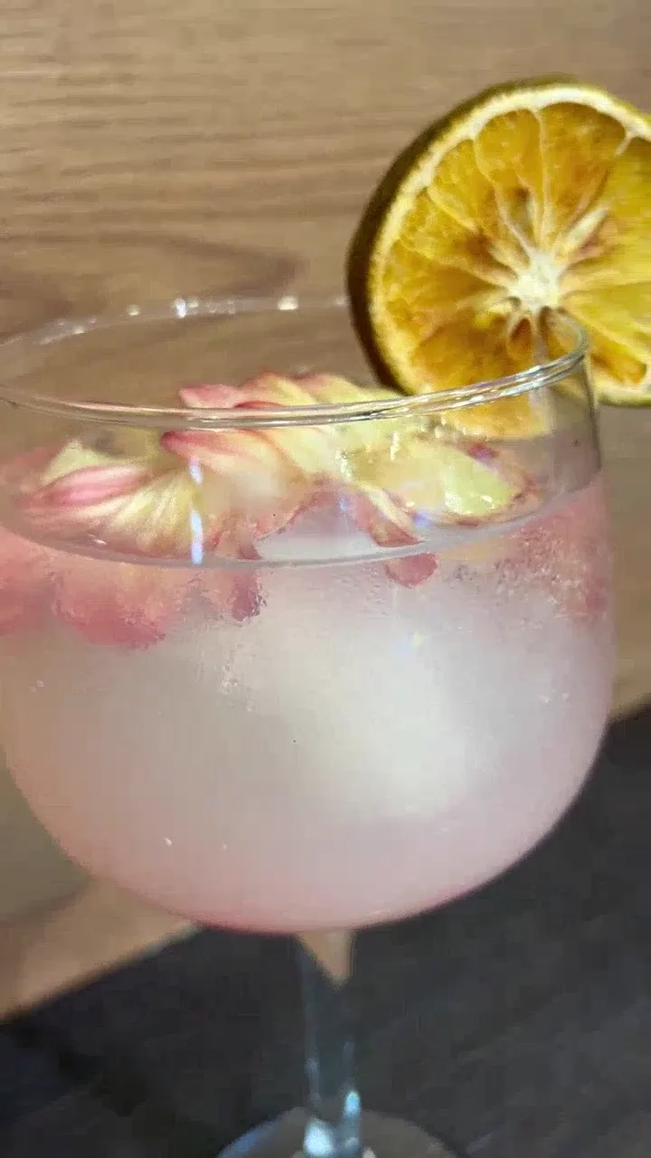 Coctel de la cafetería de Pastelería Dulcita, decorado con pétalos y naranja deshidratada