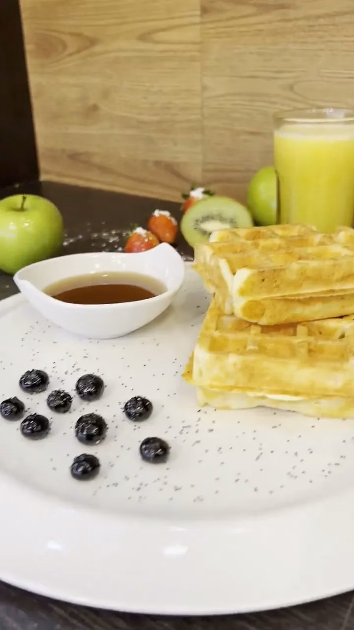 Waffle con miel de abeja, fresas, kiwi y jugo natural del restaurante de Pastelería Dulcita en la sede Calle 72